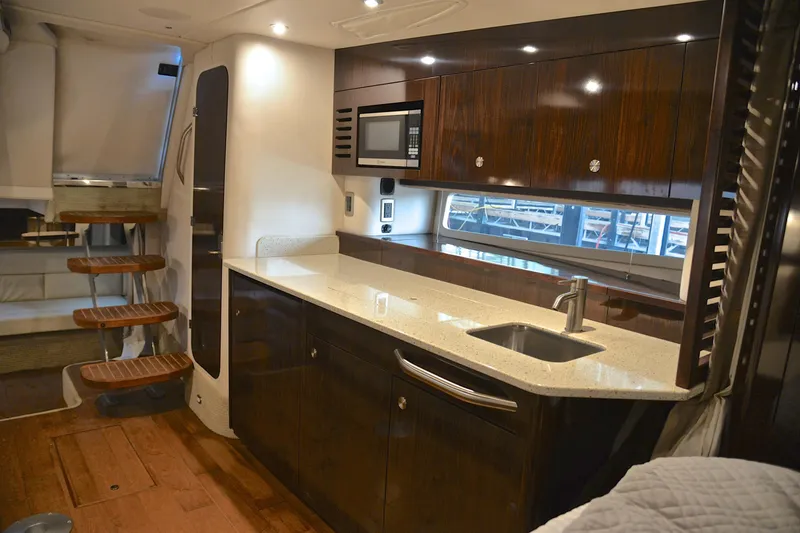 Slide: The Image of Luxurious 2016 Sea Ray Sundancer 370 yacht interior with modern kitchen and wooden cabinetry. - 34