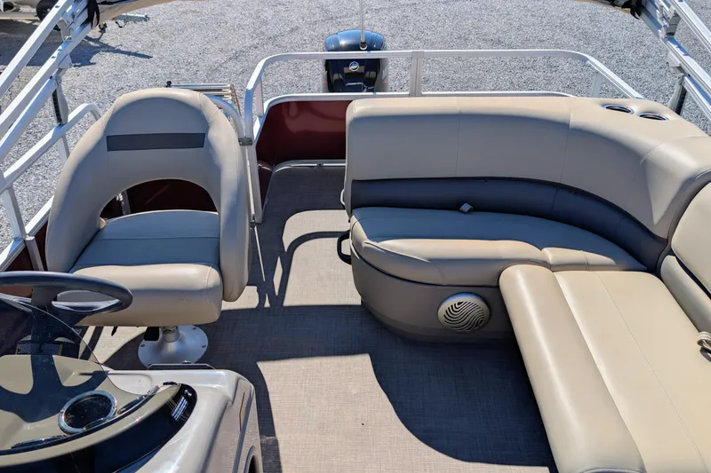 Slide: The Image of 2023 Sun Tracker Party Barge 18 interior with beige seating and steering console. - 4