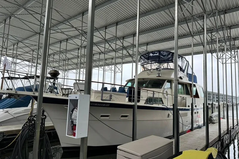 Slide: The Image of 1978 Hatteras 53 Motor Yacht docked under a covered marina. - 10