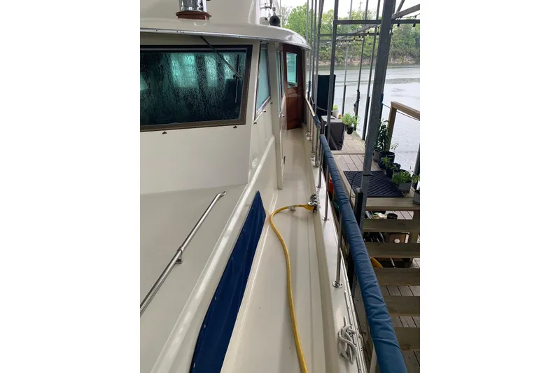 Slide: The Image of 1978 Hatteras 53 Motor Yacht docked, showing side deck and railing. - 18