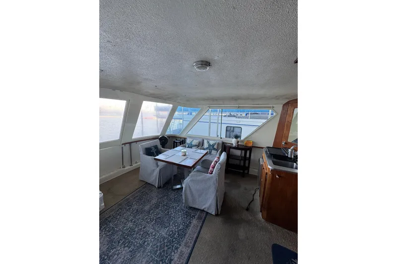 Slide: The Image of Interior of 1978 Hatteras 53 Motor Yacht with dining area and large windows. - 21