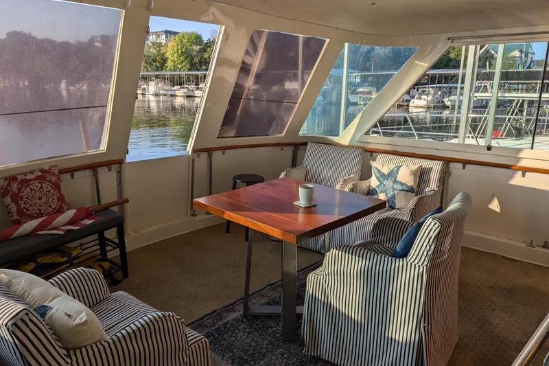 Slide: The Image of 1978 Hatteras 53 Motor Yacht interior with cozy seating and waterfront view. - 25