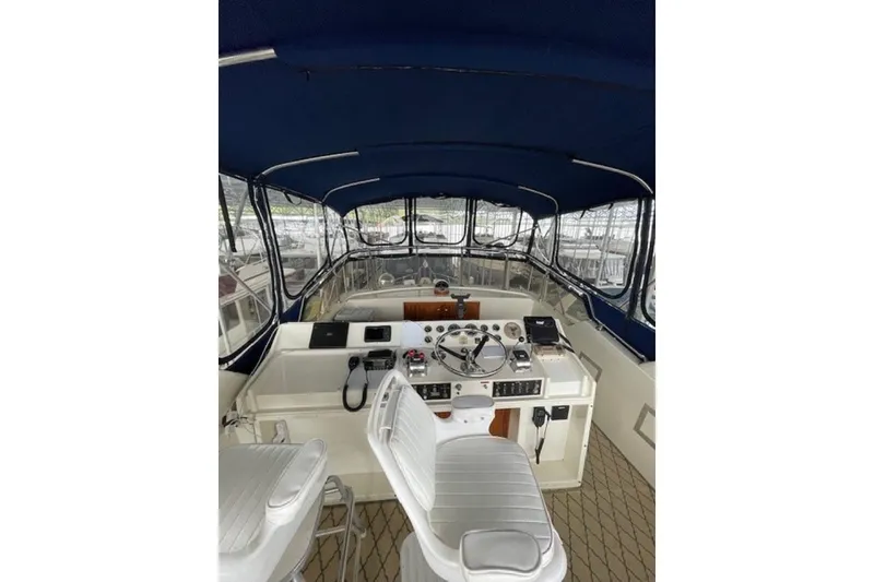 Slide: The Image of 1978 Hatteras 53 Motor Yacht helm with blue canopy and white seating. - 28