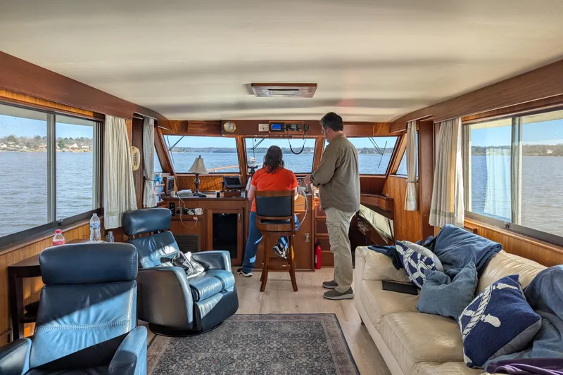 Slide: The Image of Interior of 1978 Hatteras 53 Motor Yacht with two people at helm, cozy seating area. - 35