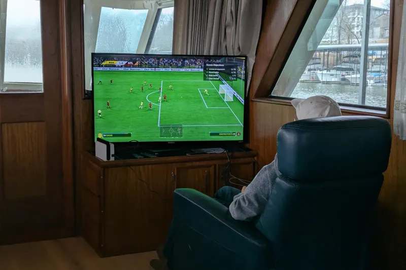 Slide: The Image of Person playing soccer video game on a 1978 Hatteras 53 Motor Yacht. - 37