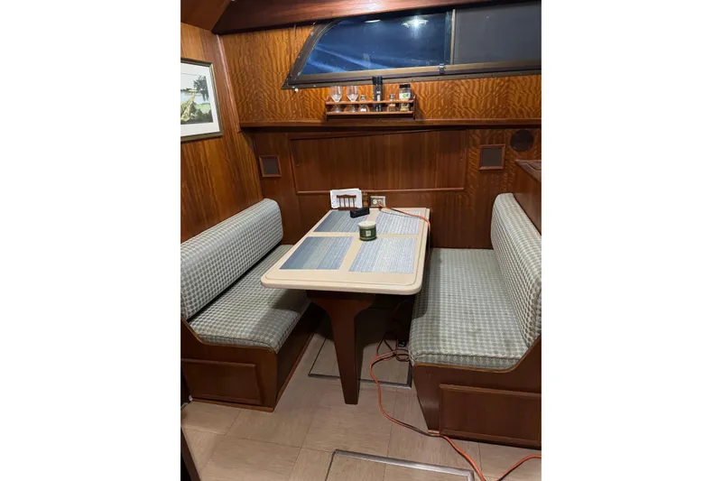 Slide: The Image of Cozy dining area in a 1978 Hatteras 53 Motor Yacht with wood paneling and cushioned seating. - 45