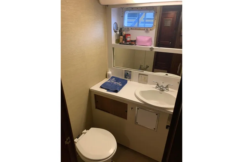 Slide: The Image of 1978 Hatteras 53 Motor Yacht bathroom with sink, mirror, and toilet. - 55
