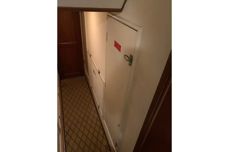 Slide: The Image of Narrow hallway inside 1978 Hatteras 53 Motor Yacht with anchor-patterned carpet. - 63