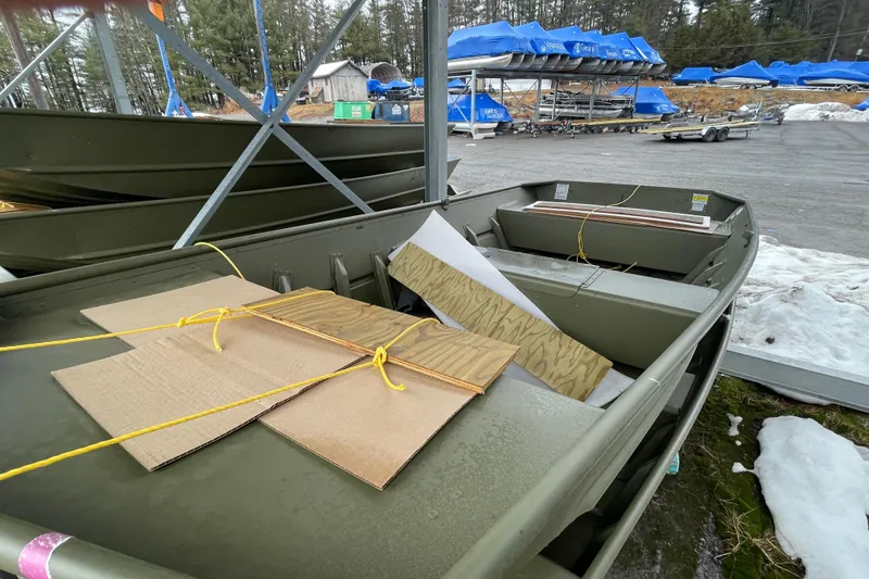 Slide: The Image of 2026 Lund 1648M boat in storage, surrounded by snow and other covered boats. - 7