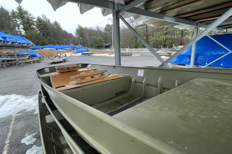 Slide: The Image of 2026 Lund 1852MT boat in storage, surrounded by snow and covered boats. - 9