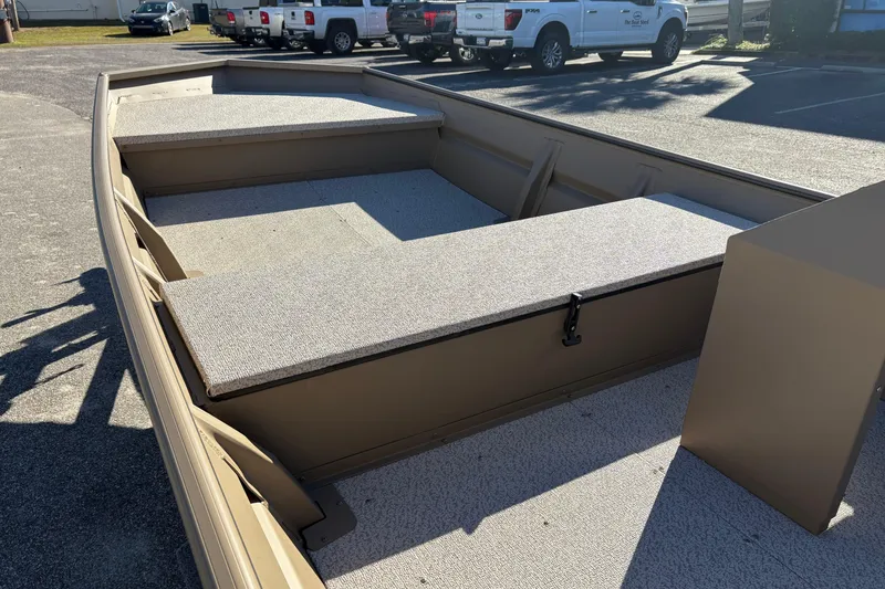 Slide: The Image of 2026 SeaArk 1648 MV boat interior with storage compartments in a parking lot. - 10