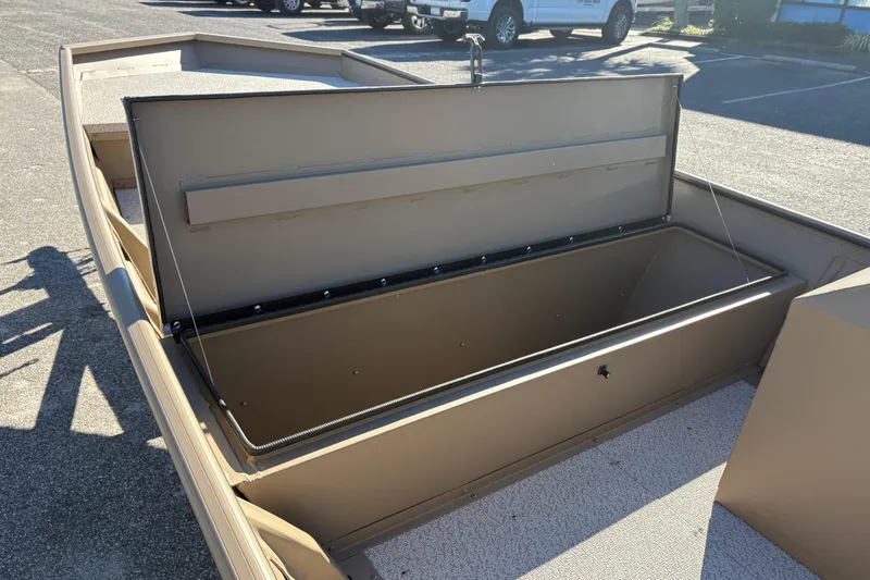 Slide: The Image of 2026 SeaArk 1648 MV boat with open storage compartment, parked outdoors. - 11