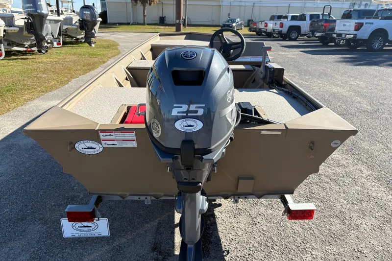 Slide: The Image of 2026 SeaArk 1648 MV boat with a 25 HP Yamaha outboard motor, parked outdoors. - 2