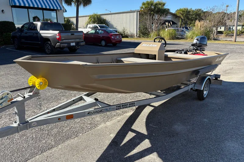 Slide: The Image of 2026 SeaArk 1648 MV boat on trailer in parking lot, with vehicles in background. - 7