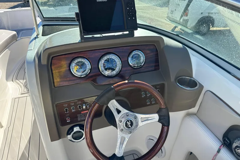 Slide: The Image of 2011 Sea Ray 240 Sundeck dashboard with steering wheel and navigation system. - 12