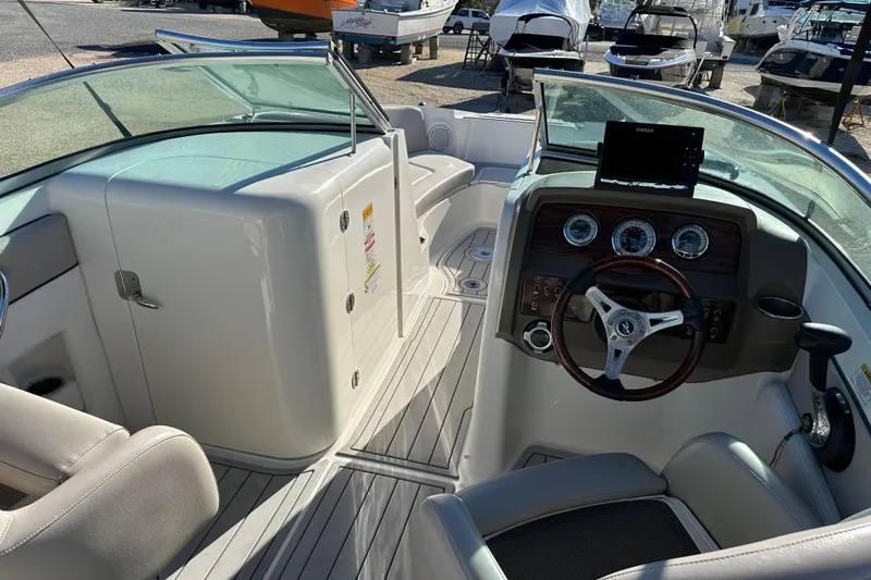 Slide: The Image of Interior view of a 2011 Sea Ray 240 Sundeck boat, featuring steering wheel and dashboard. - 13