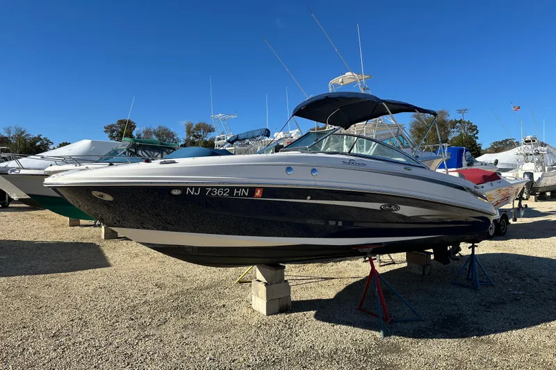 Slide: The Image of 2011 Sea Ray 240 Sundeck boat on stands in a marina under clear blue sky. - 4