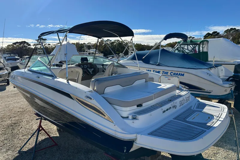 Slide: The Image of 2011 Sea Ray 240 Sundeck boat with canopy, parked in a marina. - 6