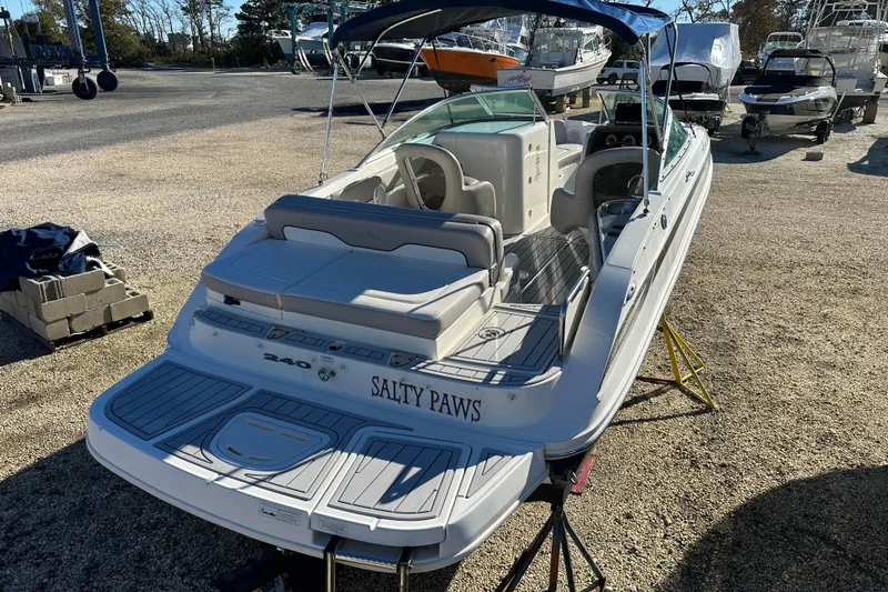 Slide: The Image of 2011 Sea Ray 240 Sundeck boat with "Salty Paws" name, parked on a stand. - 7