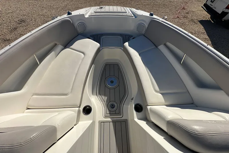 Slide: The Image of 2011 Sea Ray 240 Sundeck boat interior with white cushioned seating and deck. - 9