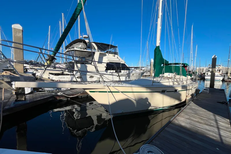 Slide: The Image of 1985 Caliber 47LRC sailboat docked in marina, clear blue sky, calm water. - 1