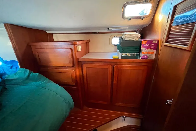 Slide: The Image of Interior of 1985 Caliber 47LRC yacht with wooden cabinets and storage area. - 13