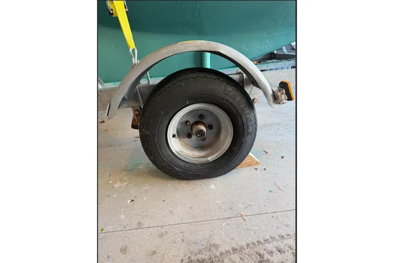 Slide: The Image of Trailer wheel of a 2002 Herreshoff 12 1/2 boat, secured with a yellow strap. - 10
