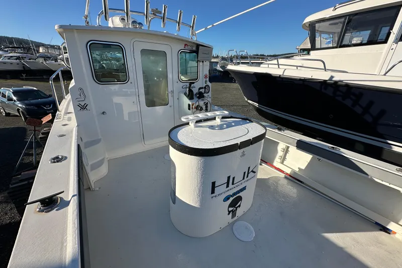 Slide: The Image of 2019 Parker 2820 XLD Sport Cabin boat docked, featuring spacious deck and fishing equipment. - 14