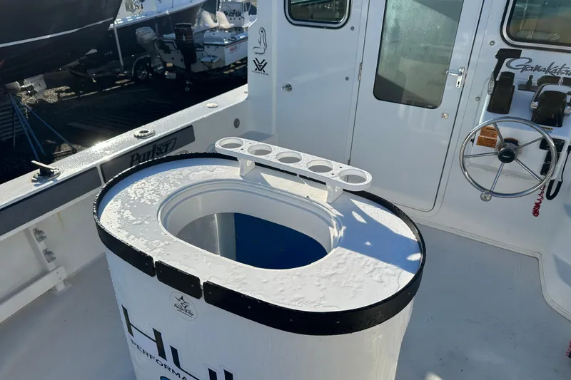 Slide: The Image of 2019 Parker 2820 XLD Sport Cabin boat interior with steering wheel and rod holders. - 18
