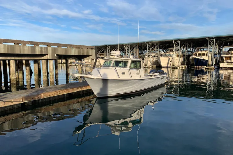 Slide: The Image of 2019 Parker 2820 XLD Sport Cabin boat docked at a marina under clear skies. - 3