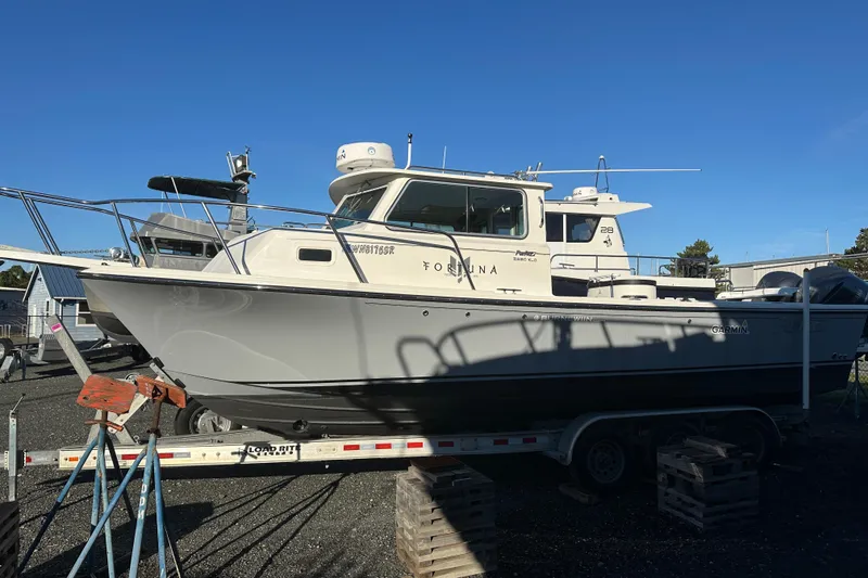 Slide: The Image of 2019 Parker 2820 XLD Sport Cabin boat on trailer under clear blue sky. - 8