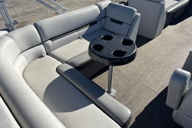 Slide: The Image of 2022 Sweetwater 2286 pontoon boat interior with gray seating and a round table. - 12