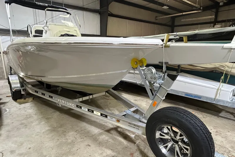The Image of 2024 Tidewater 198 CC Adventure boat on a Venture trailer in a warehouse. - 0