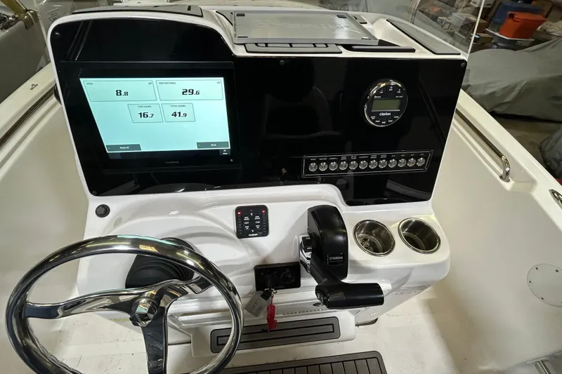 Slide: The Image of 2024 Tidewater 198 CC Adventure boat dashboard with steering wheel and digital display. - 11