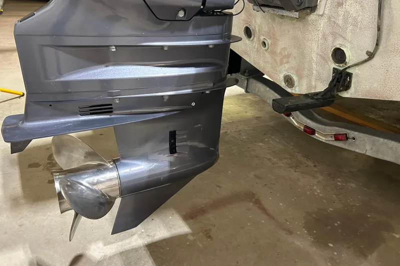Slide: The Image of 2024 Tidewater 198 CC Adventure boat propeller and motor detail in a garage setting. - 25