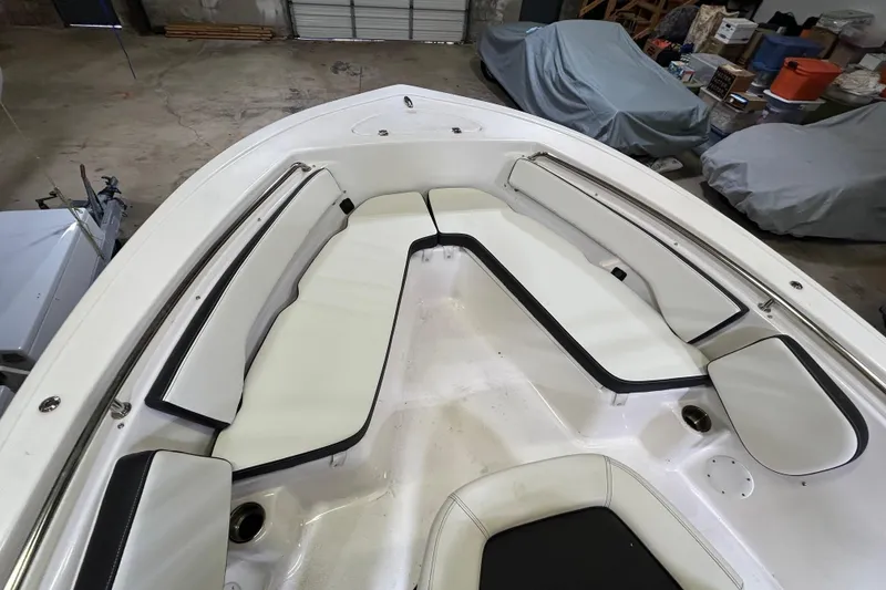 Slide: The Image of 2024 Tidewater 198 CC Adventure boat interior with white cushioned seating in a garage setting. - 5