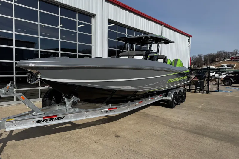 Slide: The Image of 2026 Sunsation 32 CCX boat on trailer outside a modern building. - 2