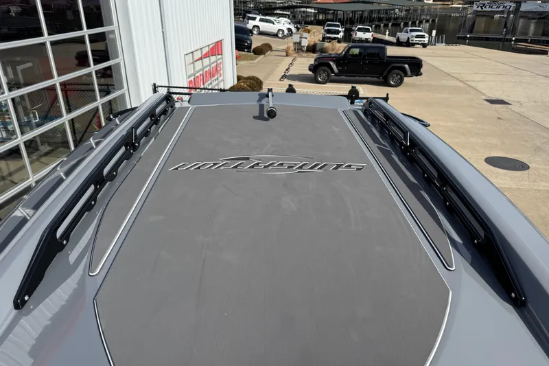 Slide: The Image of 2026 Sunsation 32 CCX boat deck with logo, parked near vehicles. - 24
