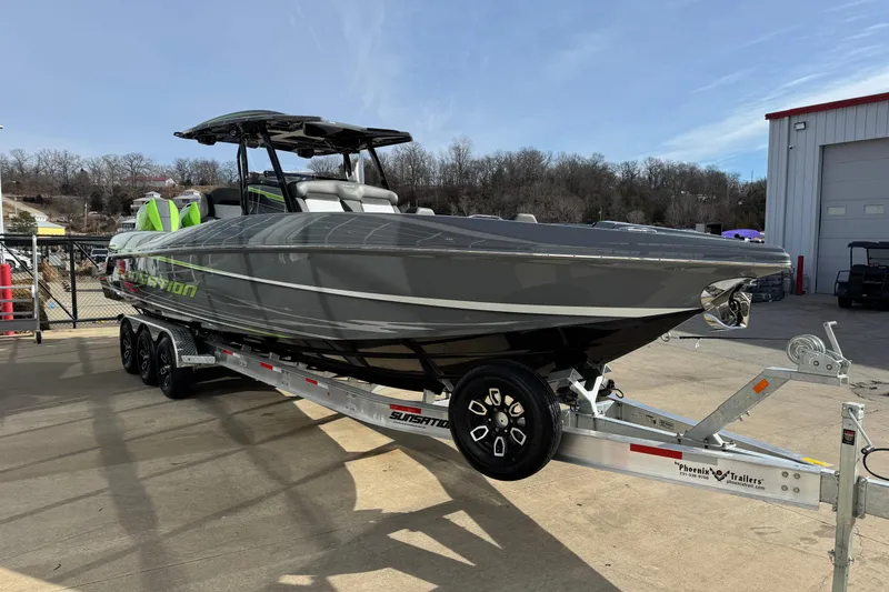 Slide: The Image of 2026 Sunsation 32 CCX boat on trailer, sleek gray design, parked outdoors. - 3