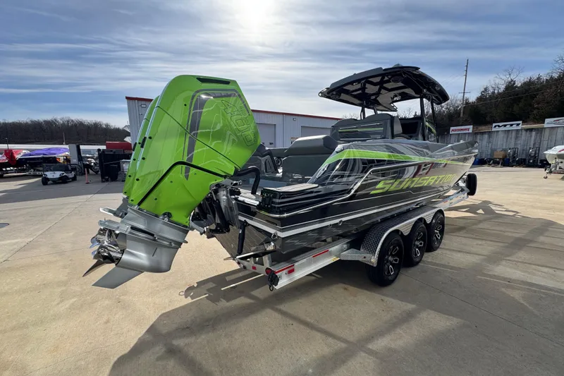 Slide: The Image of 2026 Sunsation 32 CCX boat with vibrant green engine, parked on a trailer. - 4