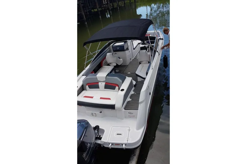 Slide: The Image of 2018 Four Winns HD240 OB boat with black canopy, docked on calm water. - 22