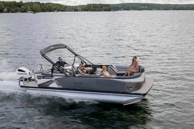 The Image of 2026 Tahoe Pontoon LTZ Entertainer cruising on a scenic lake with passengers. - 0