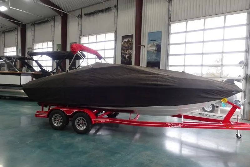 Slide: The Image of 2008 Crownline 23 SS boat covered on red trailer in indoor showroom. - 19