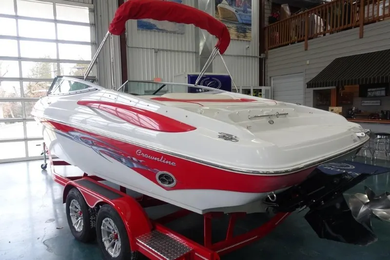 Slide: The Image of 2008 Crownline 23 SS boat in showroom, red and white design, on trailer. - 2