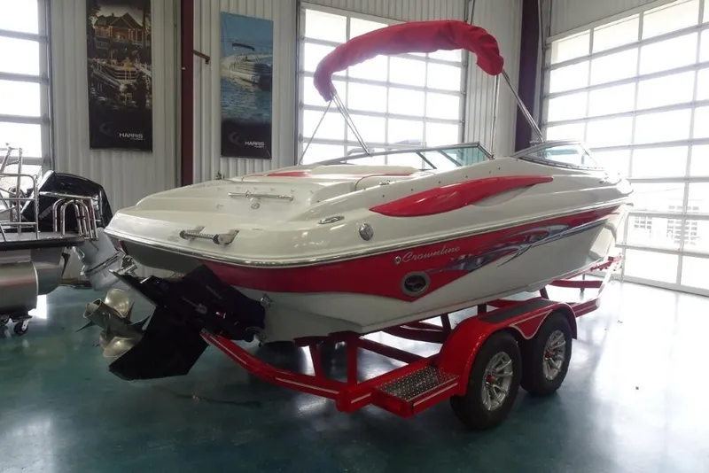 Slide: The Image of 2008 Crownline 23 SS boat with red accents on a trailer in a showroom. - 3