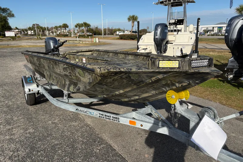 Slide: The Image of 2026 SeaArk 1752 Slayer X boat on trailer, camo design, outdoor setting. - 6