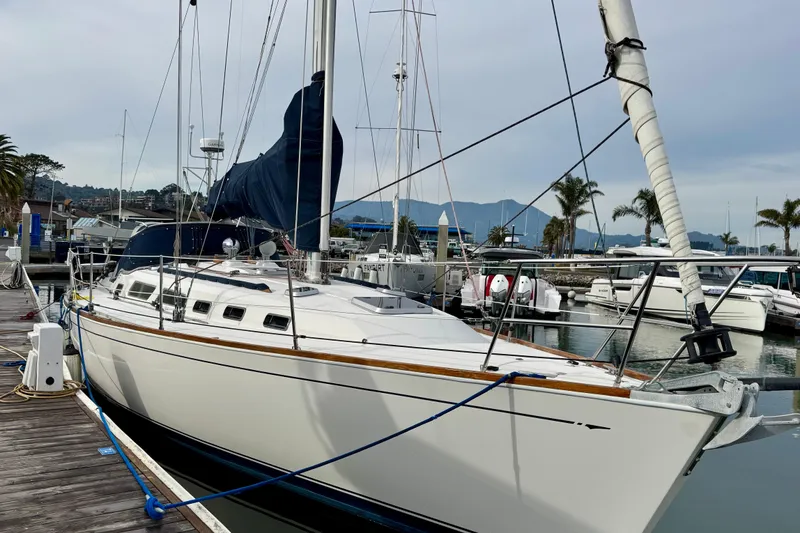 Slide: The Image of 2000 Sabre 402 sailboat docked at marina with palm trees and mountains in background. - 1