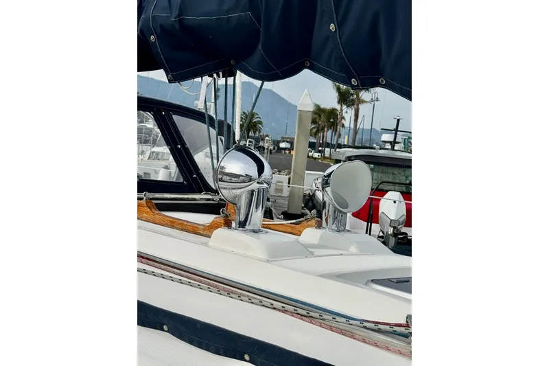 Slide: The Image of 2000 Sabre 402 sailboat with chrome fittings and navy canopy in marina setting. - 11