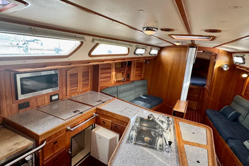 Slide: The Image of Interior of 2000 Sabre 402 yacht with wood finish, kitchen, and seating area. - 26