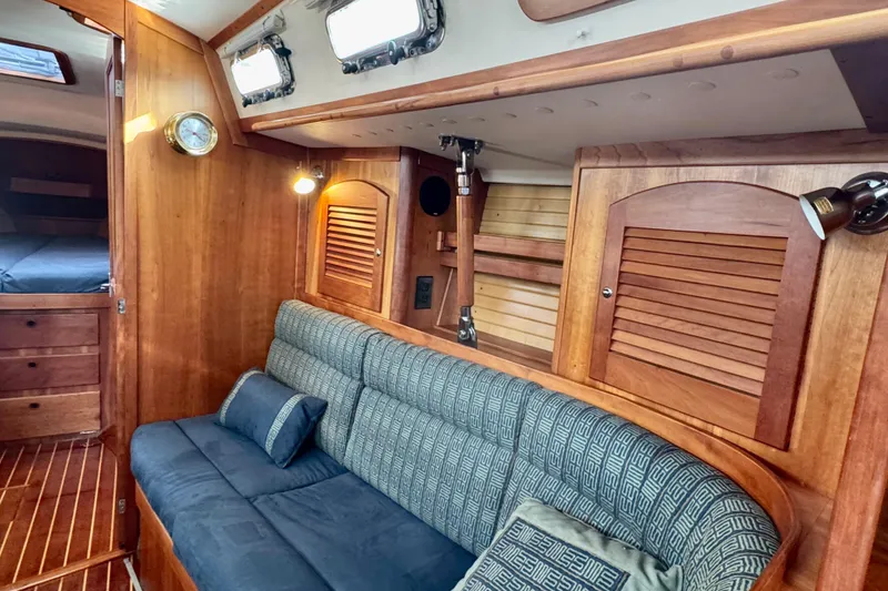 Slide: The Image of Interior of 2000 Sabre 402 yacht with wooden finish and blue cushioned seating. - 31